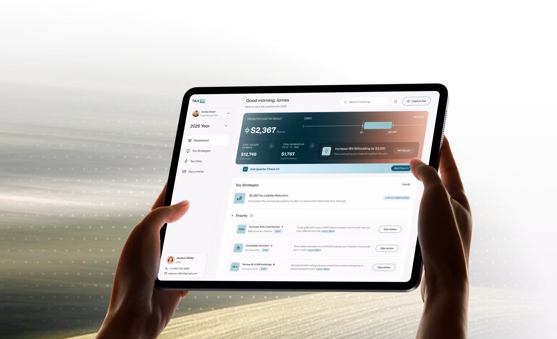 Hands holding a tablet showing a finance dashboard.