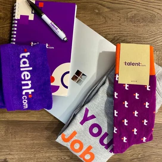 A purple notebook, matching purple socks, and a pen arranged together on a flat surface.
